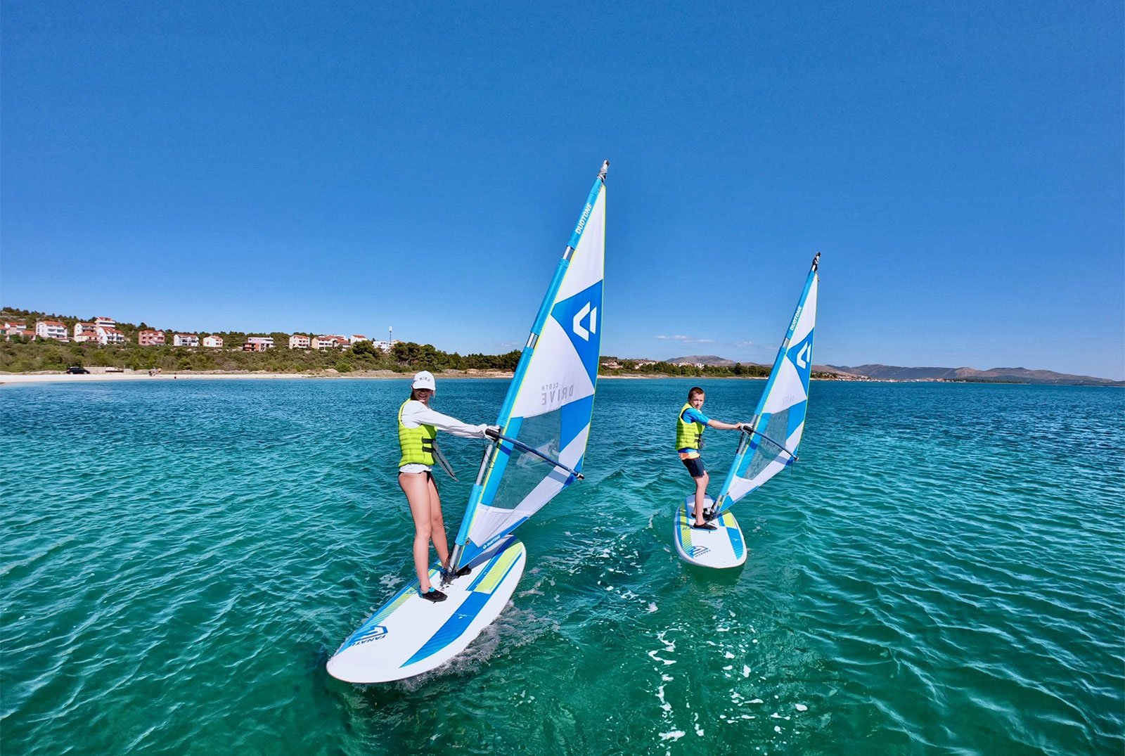 Brother-and-sister-windsurfing-in-the-safe-bay-scaled