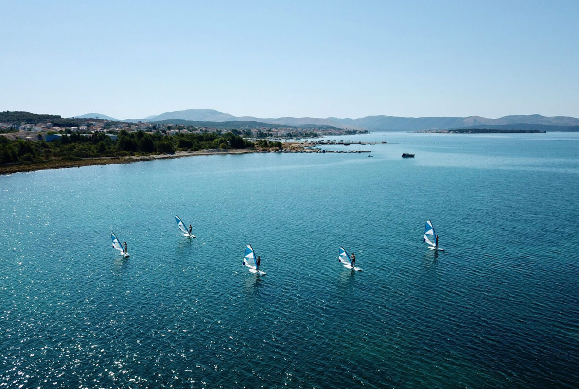 Kinder und Erwachsene lernen Windsurfen